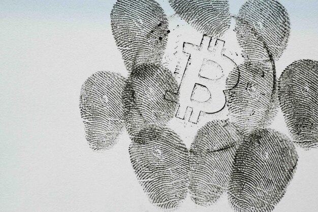 A stylized graphic of a digital fingerprint overlaid on a Bitcoin symbol, representing the tracking and identification of crypto transactions under the Travel Rule.